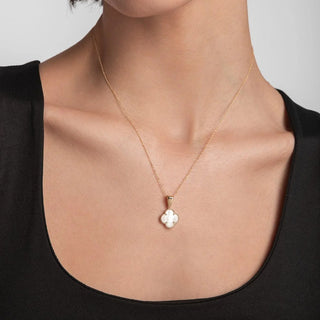 Woman wearing a necklace with a clover pendant 